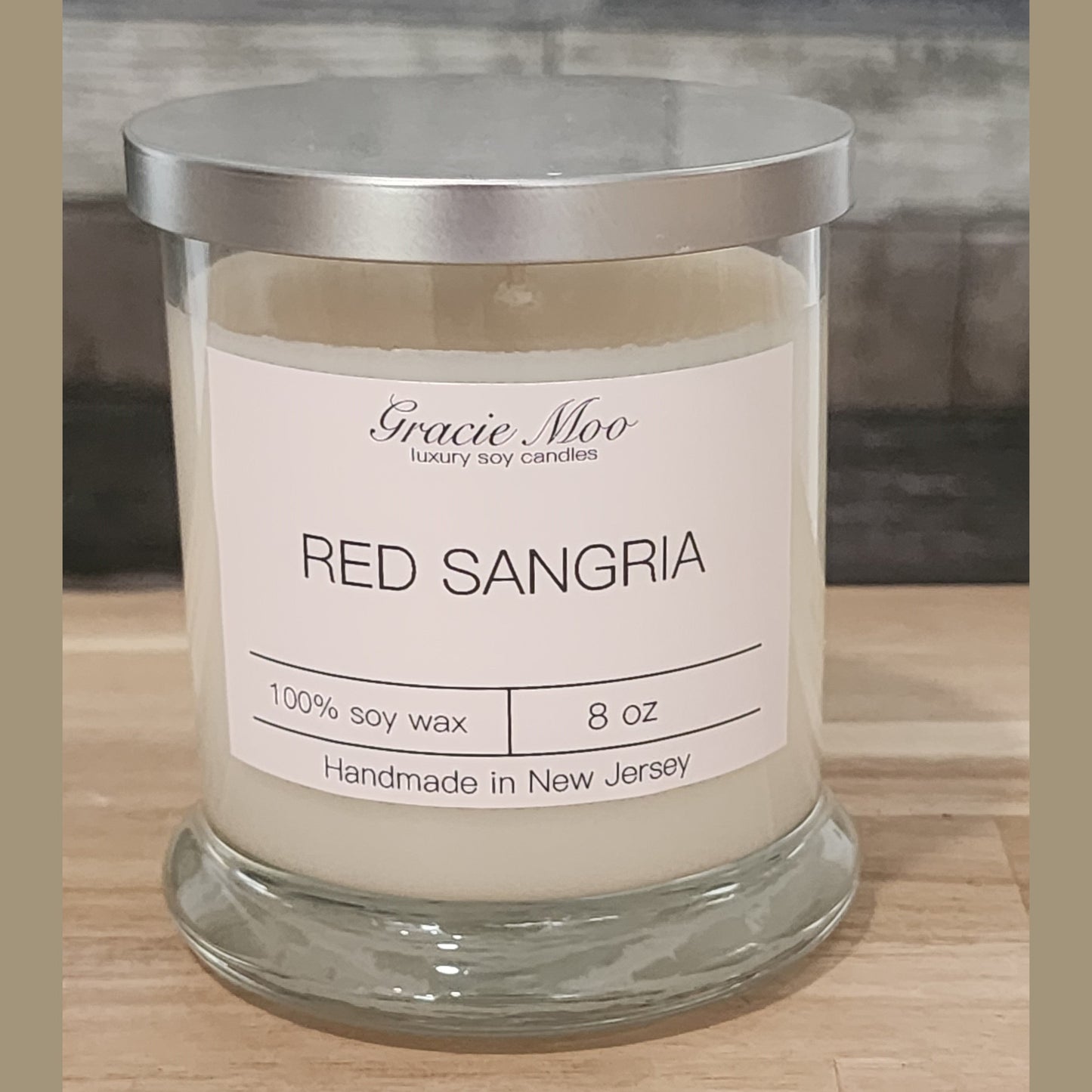 Red Sangria Status Candle by Gracie Moo Candles, featuring a vibrant red color and elegant glass container.