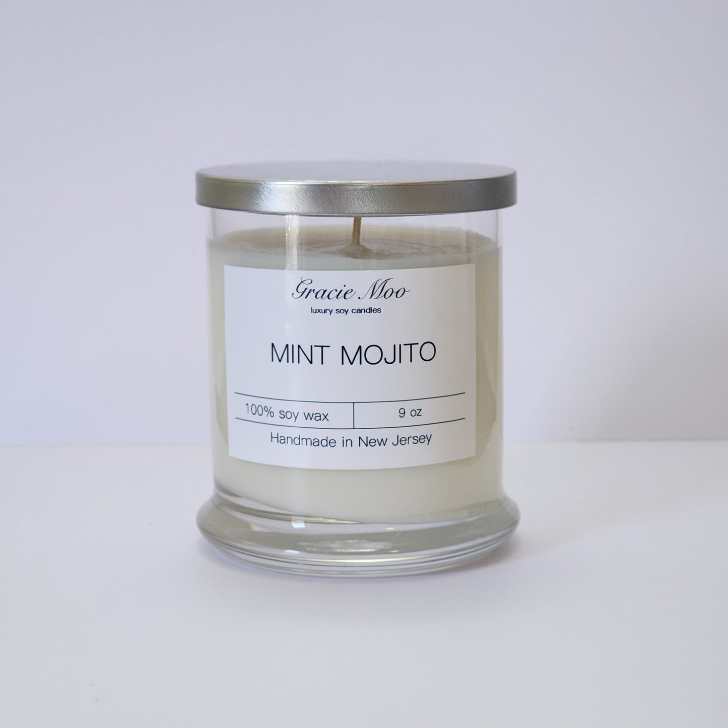 Mint Mojito Status Candle by Gracie Moo Candles, featuring a fresh mint green color and a relaxing candle flame.