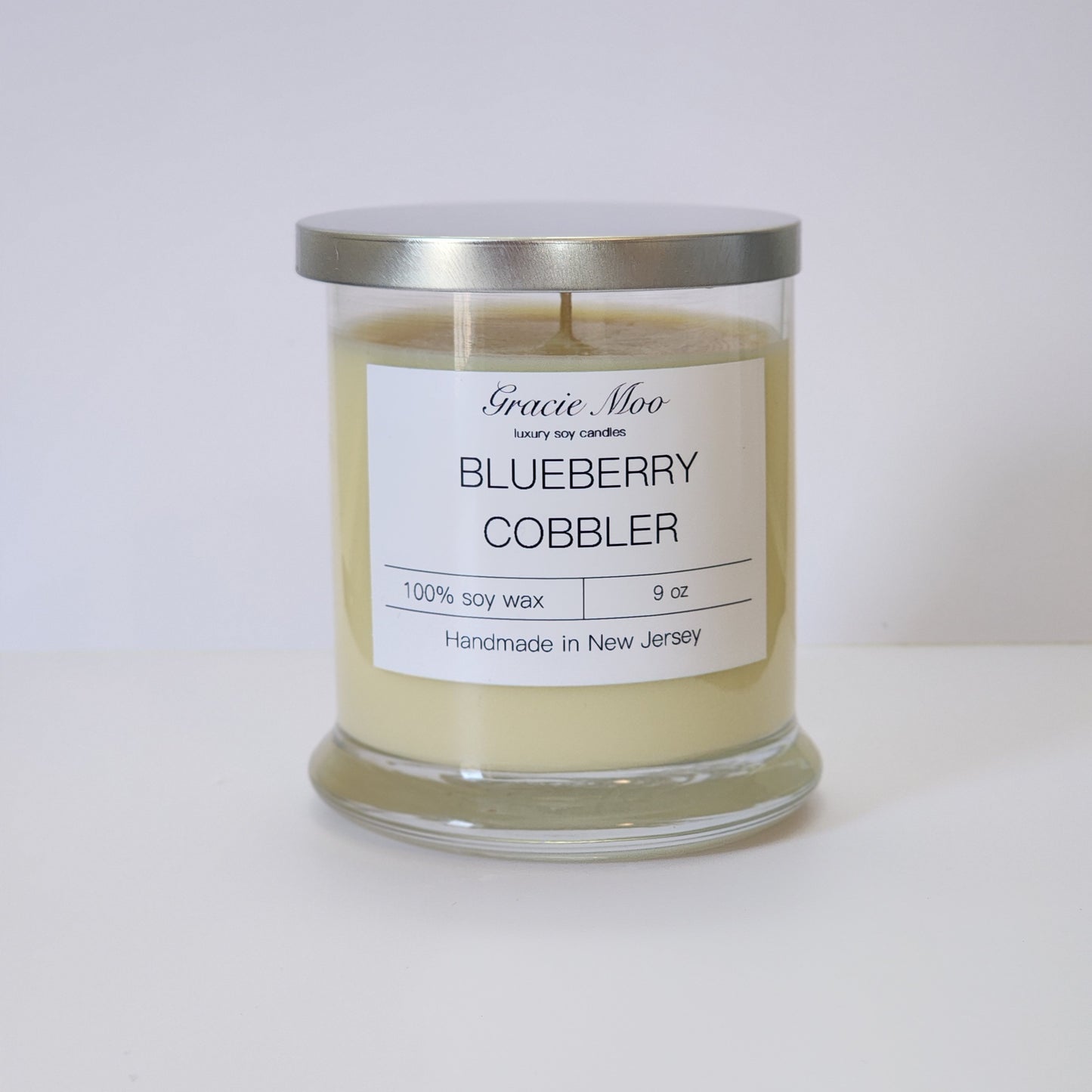 Blueberry Cobbler Status Candle by Gracie Moo, featuring a rich blue color and a cozy, inviting design.