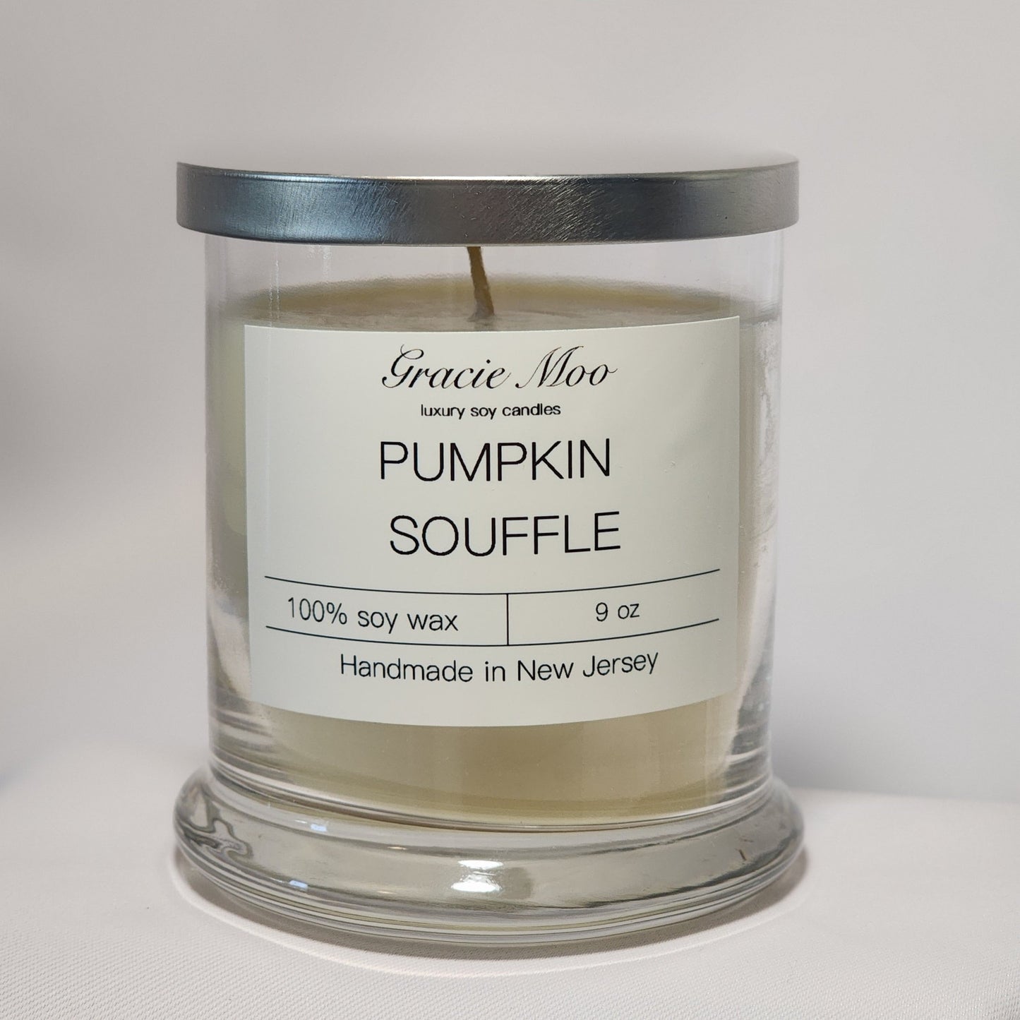 Pumpkin Soufflé candle by Gracie Moo Candles, featuring a warm orange hue and a classic glass container.