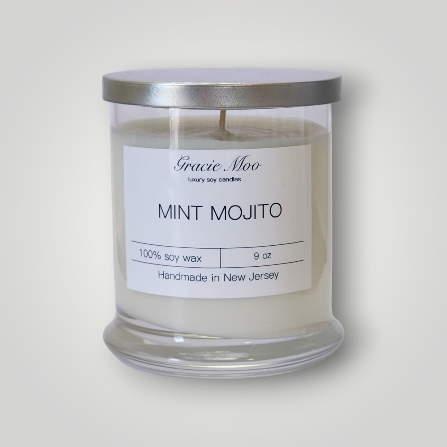 Gracie Moo Candles Mint Mojito Status Candle with fresh mint and lime scent, featuring a stylish white candle in a clear glass holder.