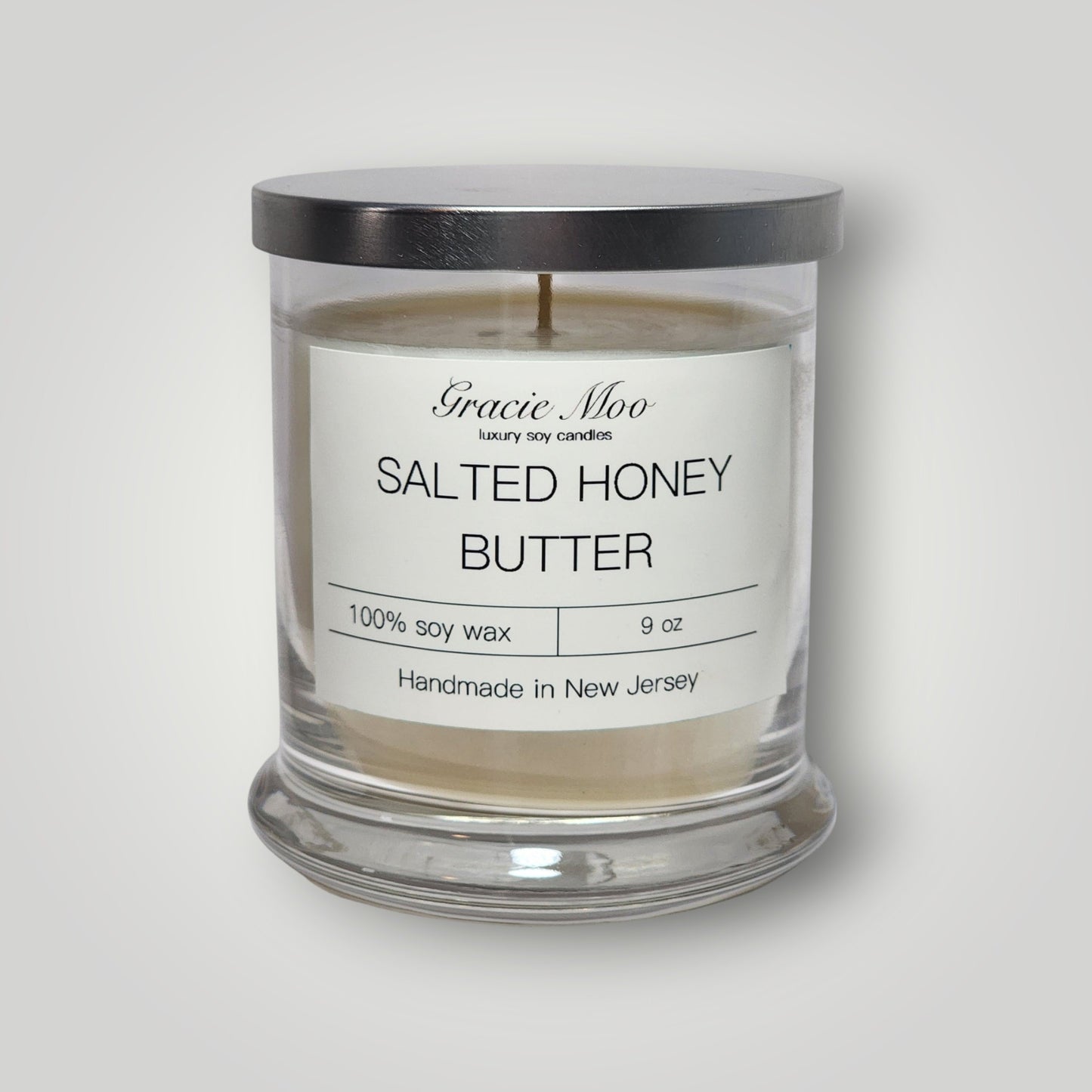 Gracie Moo Candles salted honey butter scented candle in a glass jar with a wooden wick and warm, inviting glow.