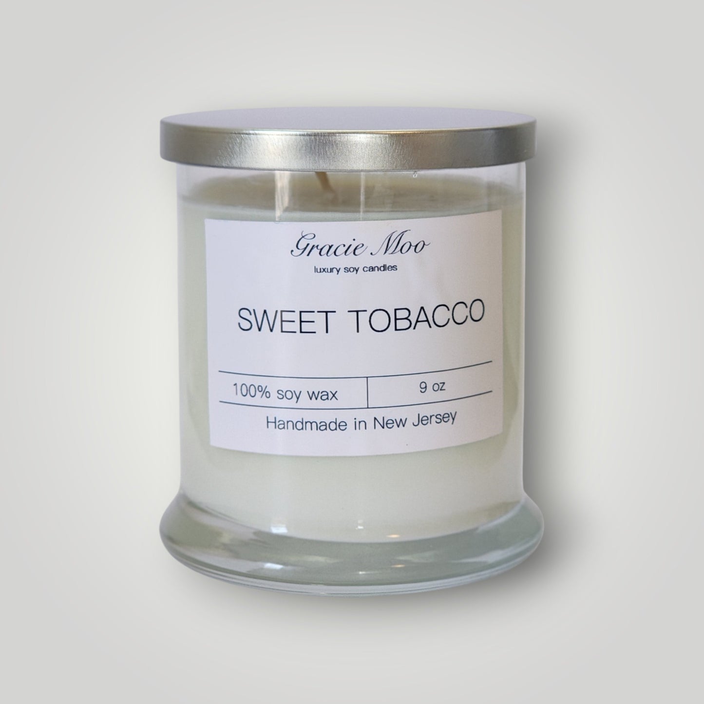 Sweet Tobacco Status Candle by Gracie Moo Candles featuring a cozy, aromatic candle in a stylish container.