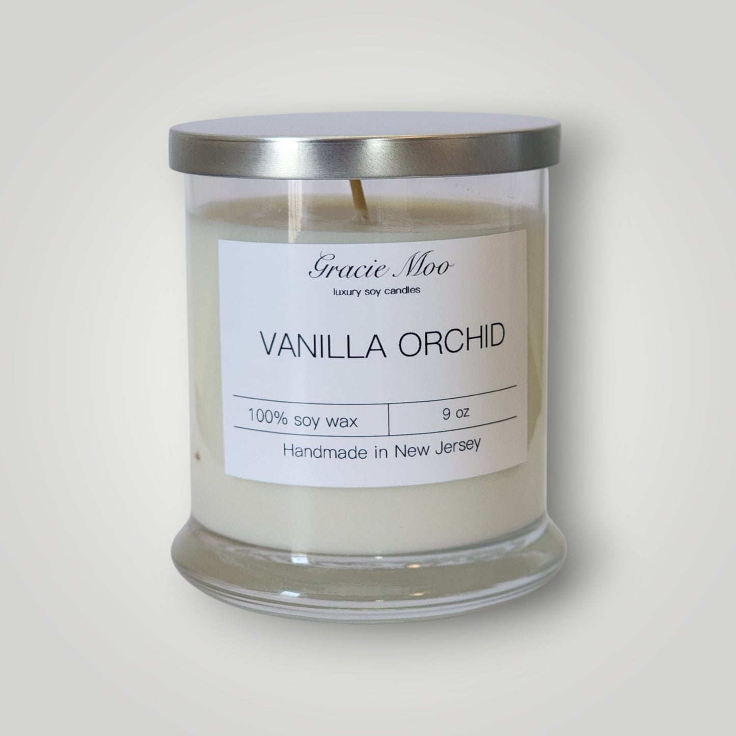 Vanilla Orchid Status Candle by GracieMoo Candles featuring a sleek white candle with subtle vanilla and orchid fragrance elements.