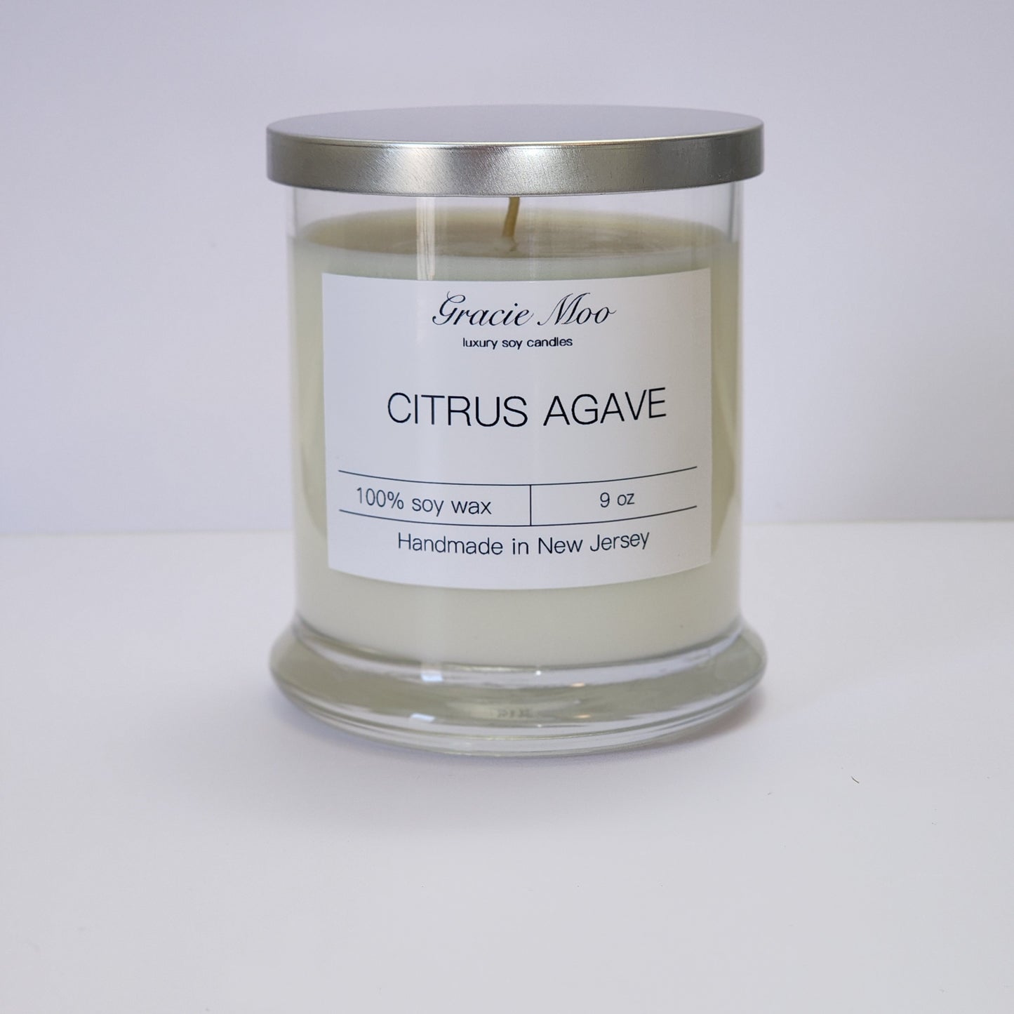 Citrus Agave Status Candle by Gracie Moo Candles with a vibrant yellow wax and a sleek glass container.
