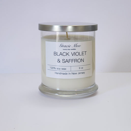 Black Violet & Saffron Status Candle by Gracie Moo Candles in a sleek black container with elegant label design.