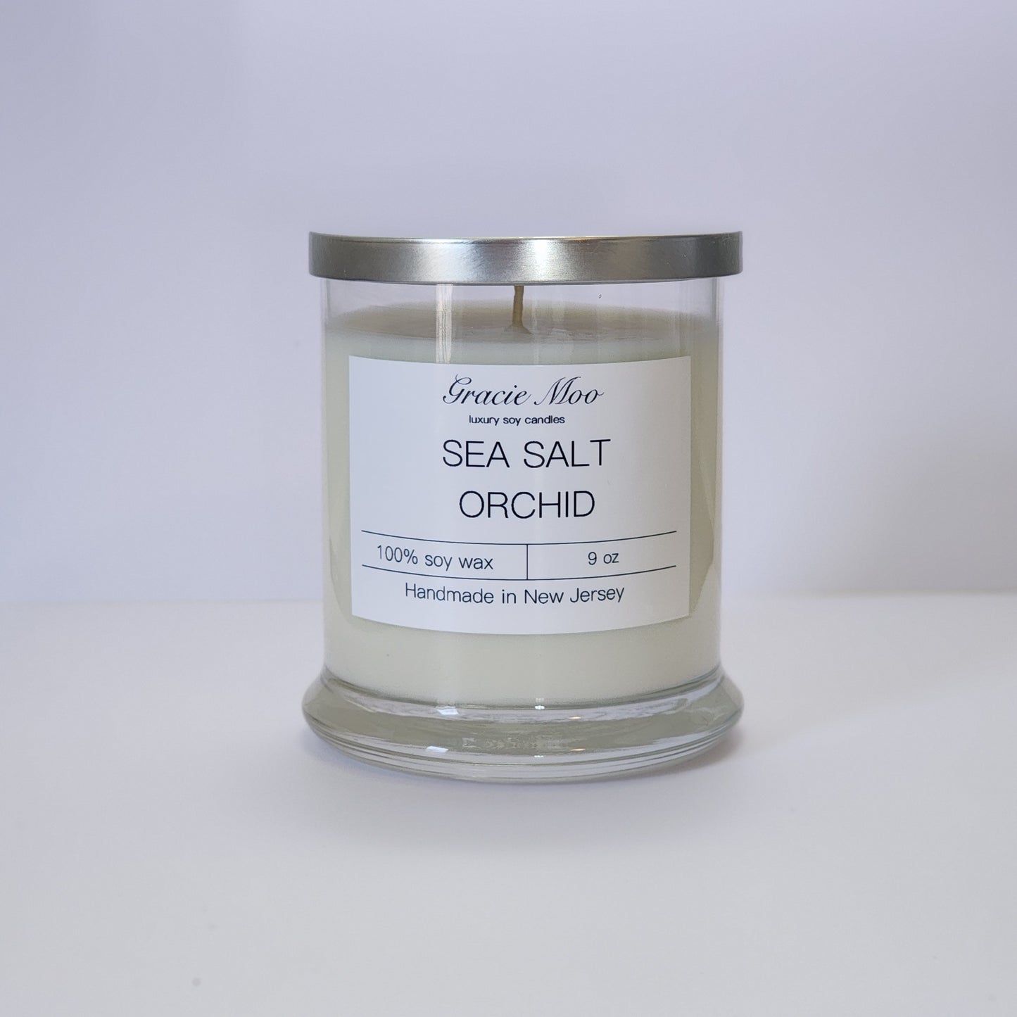 Sea Salt & Orchid candle by Gracie Moo Candles in a clear glass jar with a soft, minimalist label design.