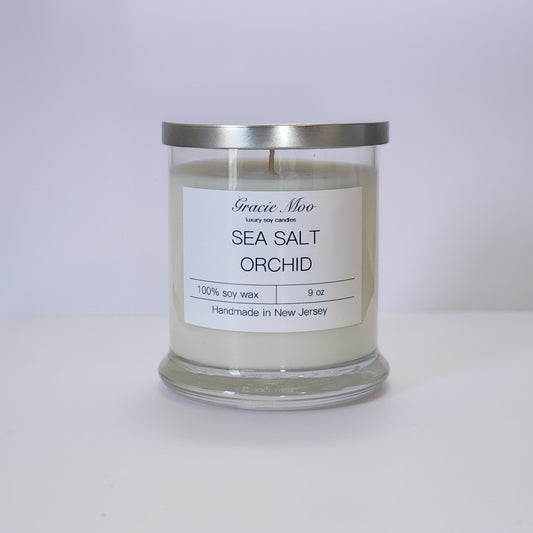 Sea Salt & Orchid candle by Gracie Moo Candles in a clear glass jar with a soft, minimalist label design.