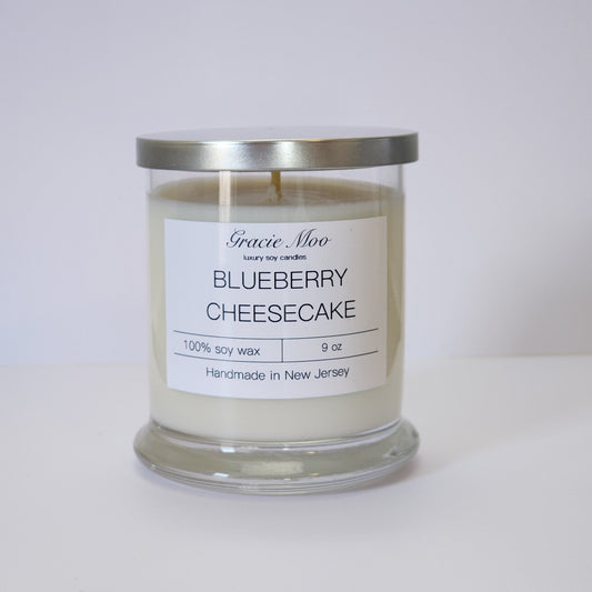 Blueberry cheesecake scented candle by Gracie Moo Candles, featuring a vibrant blue color and elegant glass jar design.