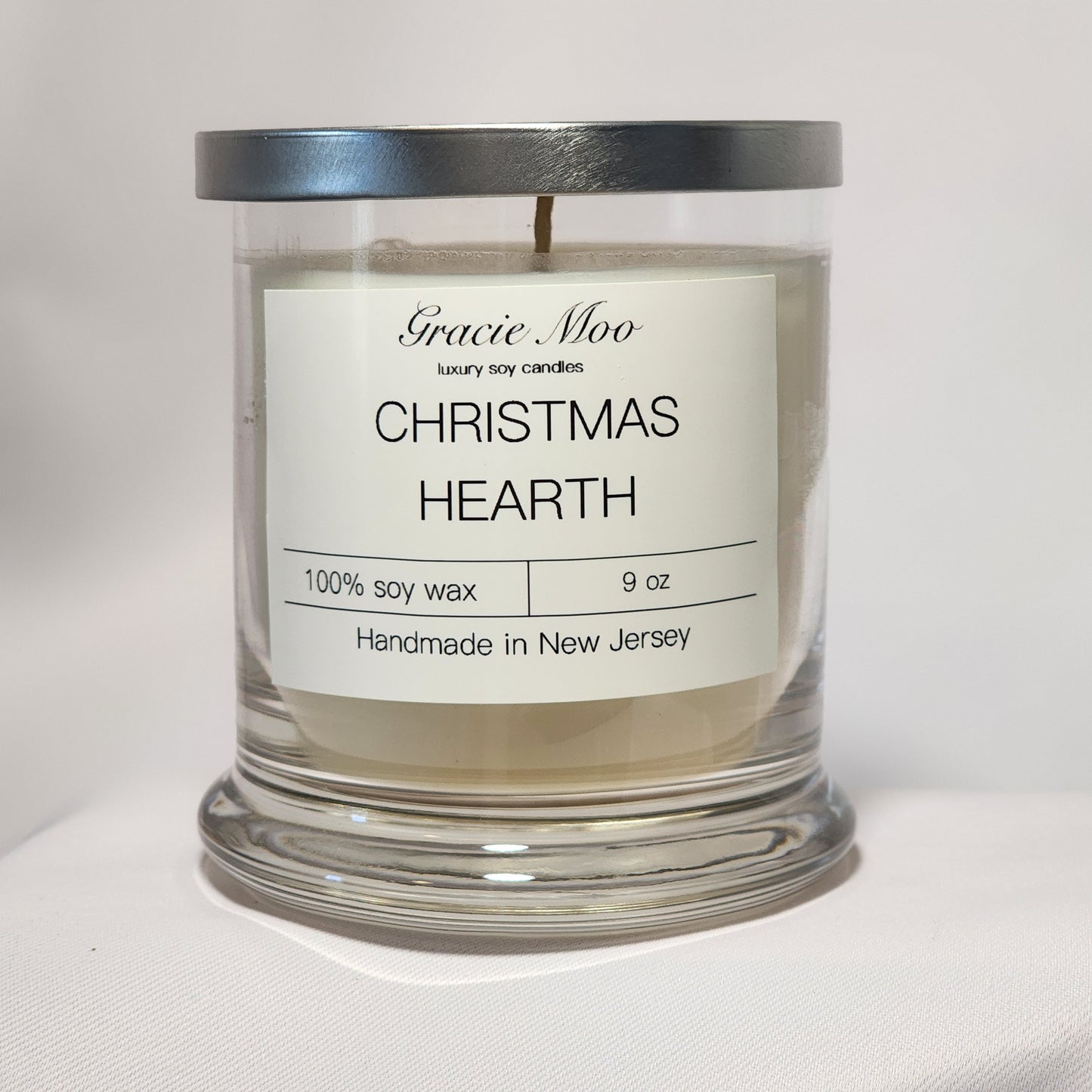 Gracie Moo Candles Christmas Hearth Status Candle with a warm glow and festive holiday design.