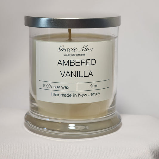 Ambered Vanilla Status Candle by GracieMoo Candles, featuring a warm glow and elegant packaging.