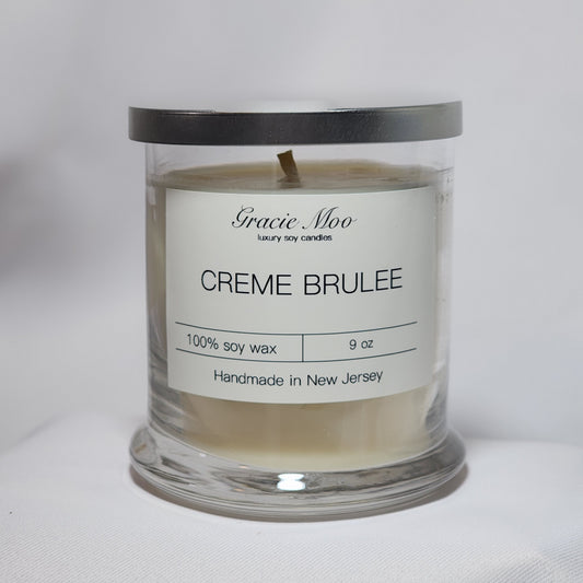 Crème Brûlée Status Candle by Gracie Moo Candles with a creamy texture and caramelized sugar top in a sleek glass jar.
