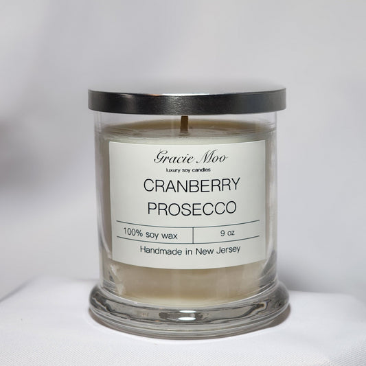 Cranberry Prosecco Status Candle by Gracie Moo Candles with a vibrant red color and elegant glass container.