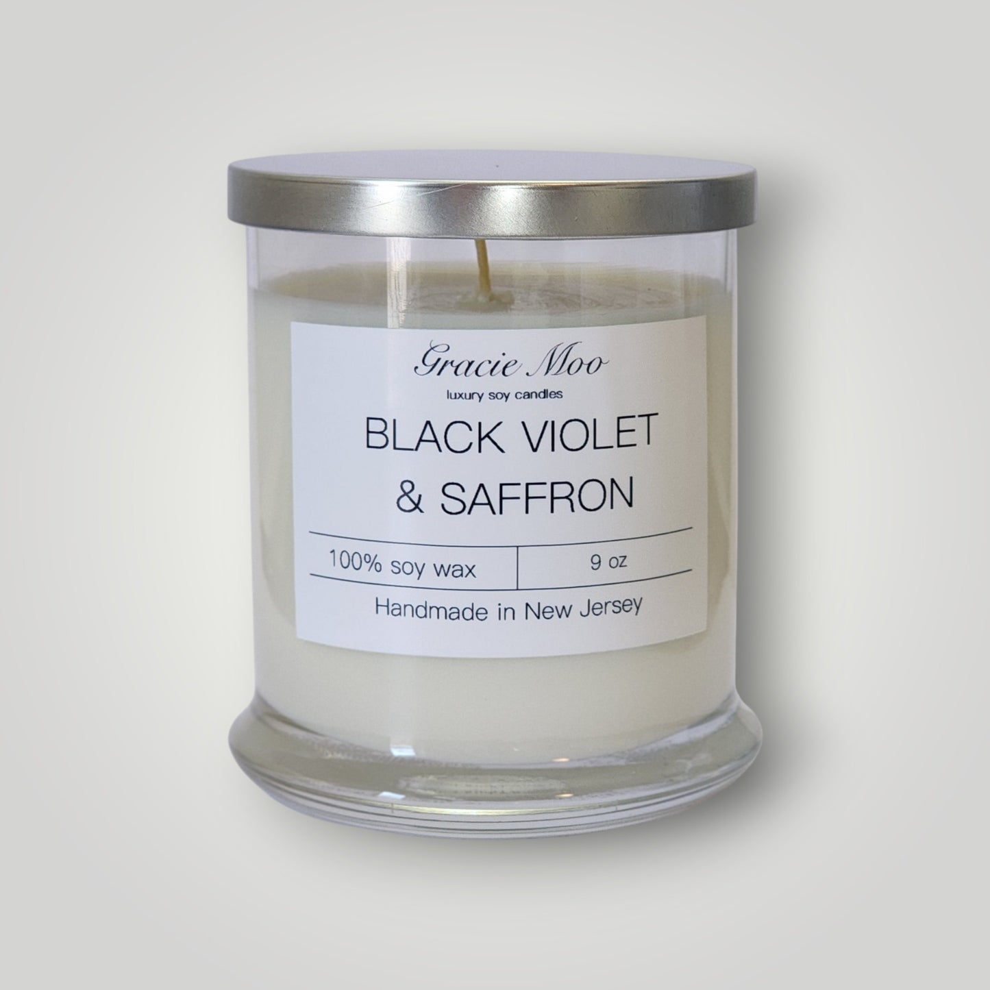 Black Violet and Saffron scented candle from Gracie Moo Candles, showcasing a sleek black candle with violet and saffron fragrance.