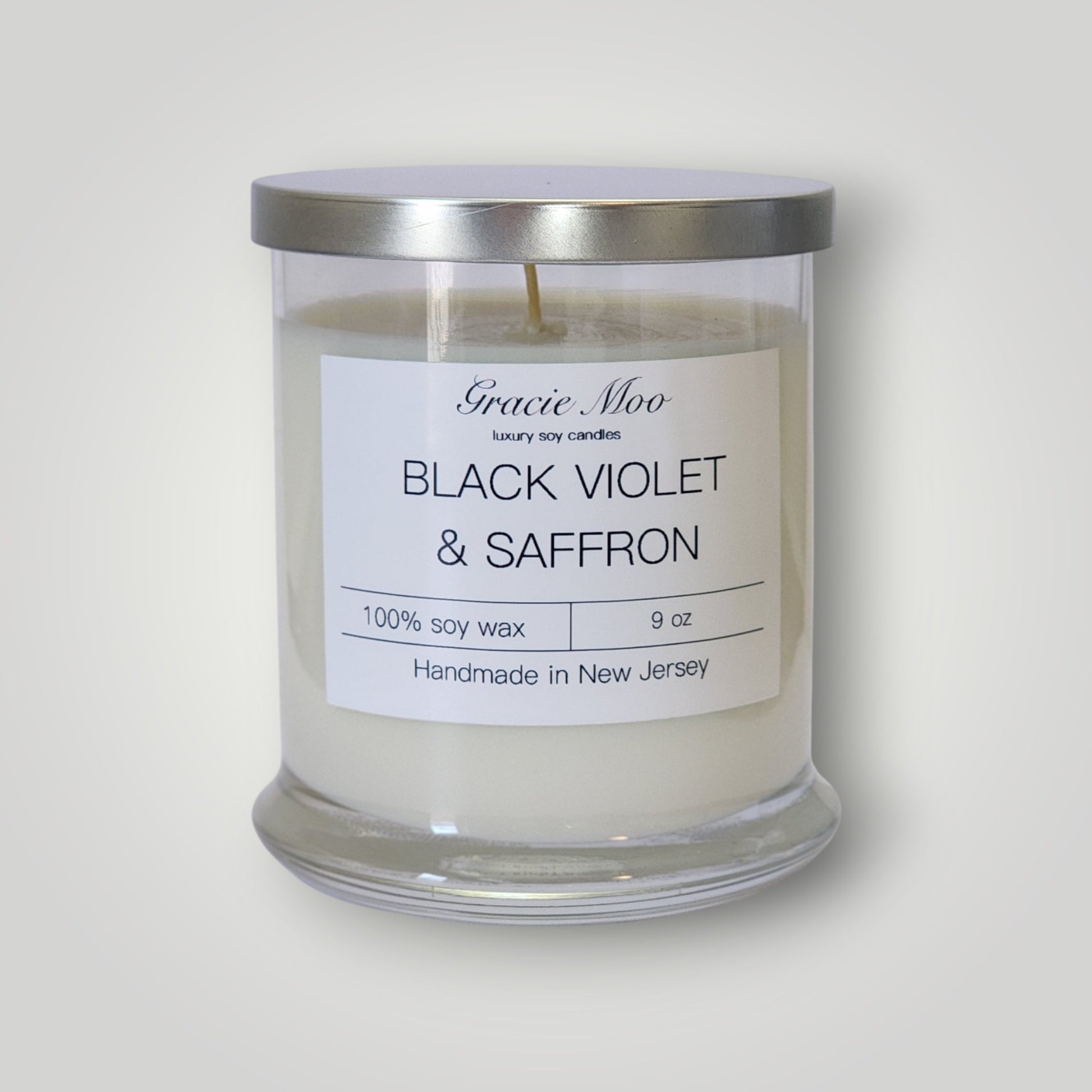 Black Violet and Saffron scented candle from Gracie Moo Candles, showcasing a sleek black candle with violet and saffron fragrance.