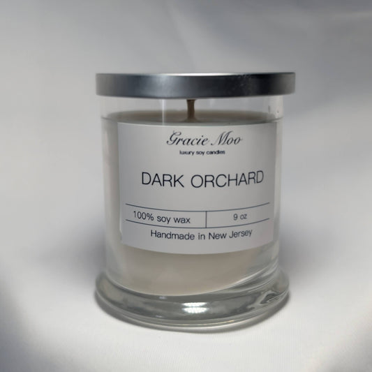 Dark Orchard Status Candle by Gracie Moo Candles, featuring a sleek dark-colored candle with a minimalist design.