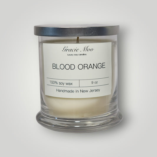 Blood Orange Status Candle by Gracie Moo Candles featuring a vibrant orange-colored candle with a blood orange scent.