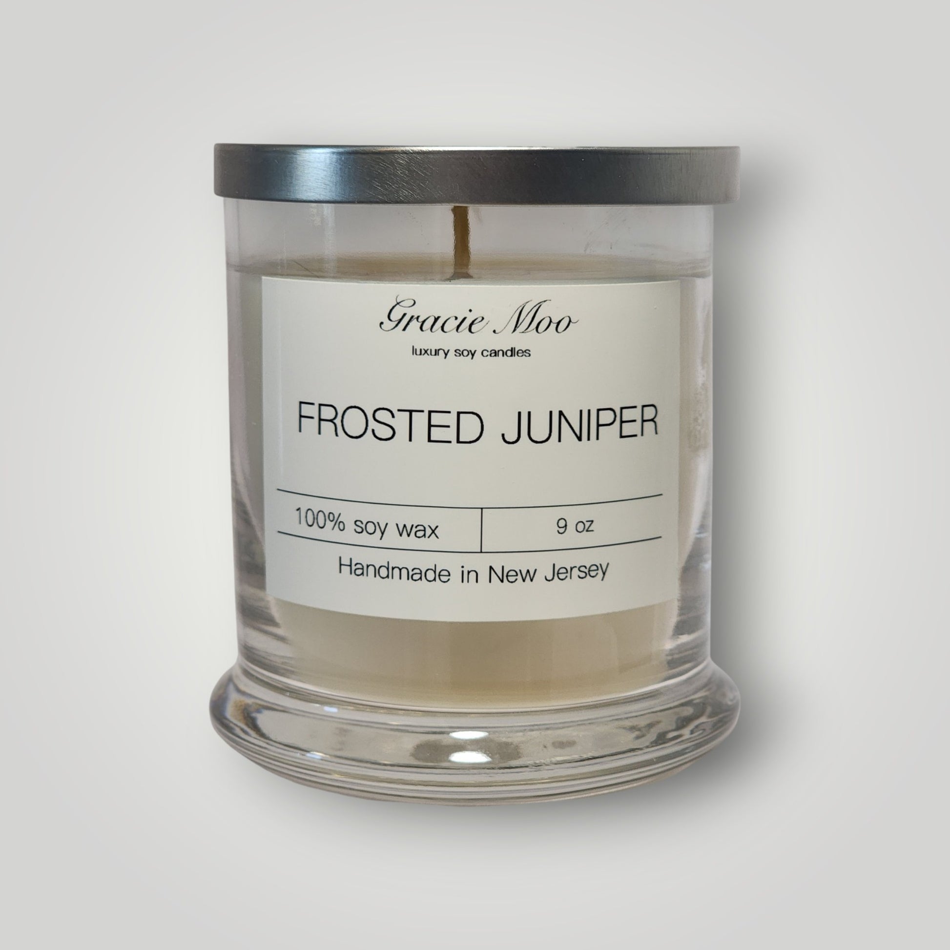 Frosted Juniper Status Candle by Gracie Moo Candles featuring a frosted glass candle with juniper design.