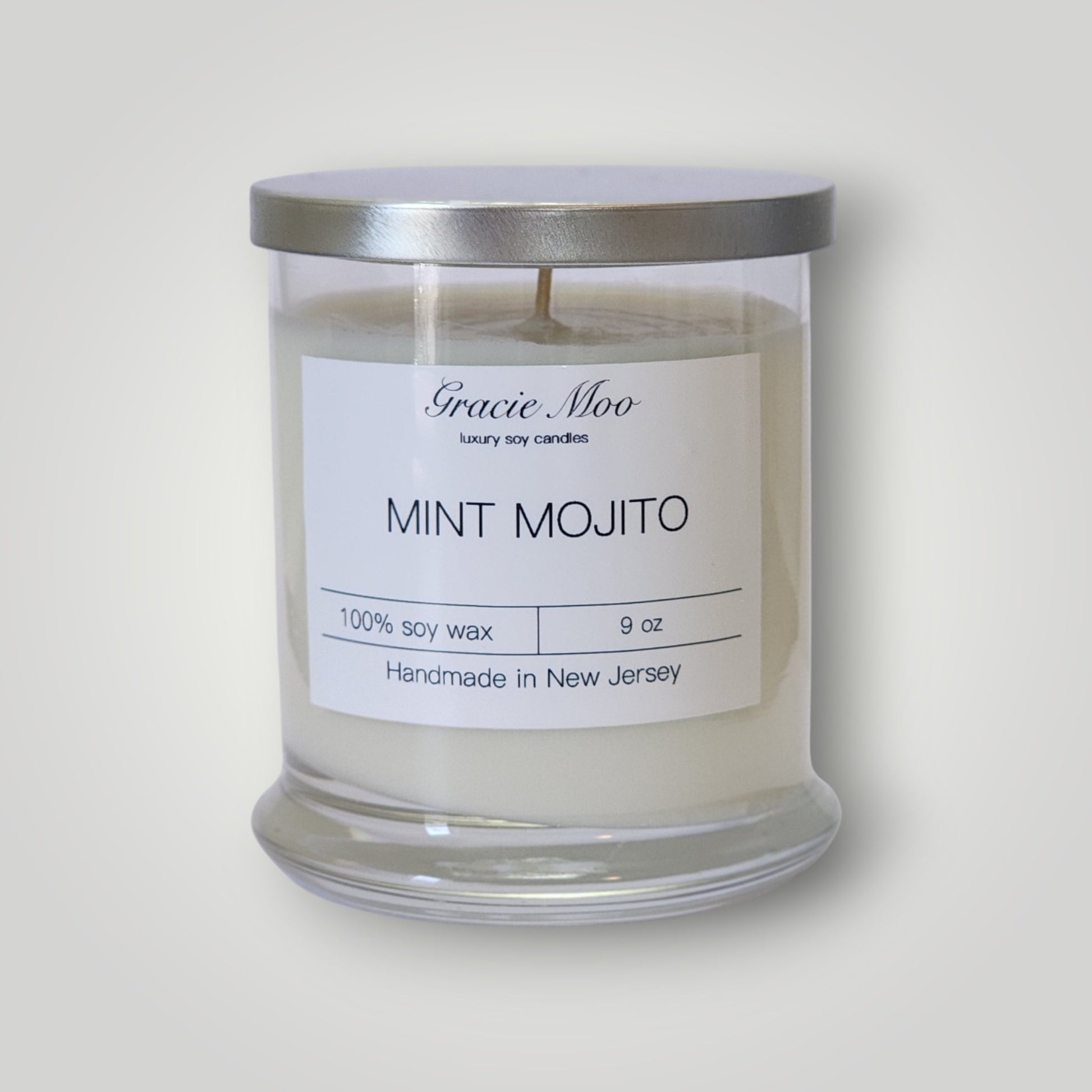 Gracie Moo Candles Mint Mojito Status Candle with fresh mint and lime scent, featuring a stylish white candle in a clear glass holder.