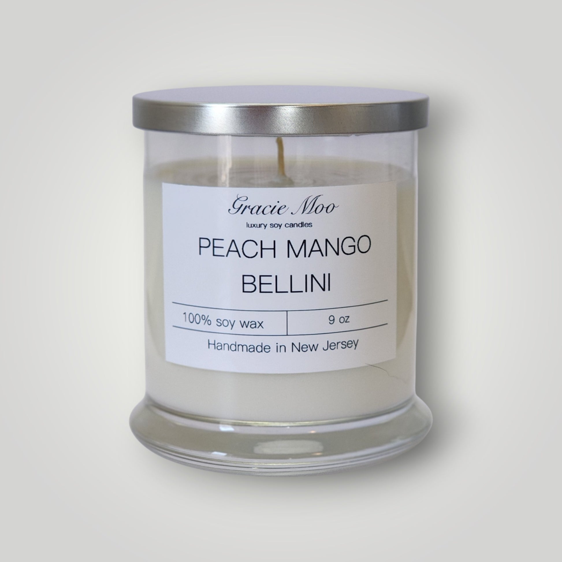 Gracie Moo Candles Peach Mango Bellini scented candle with a stylish glass container and a peach and mango fragrance theme