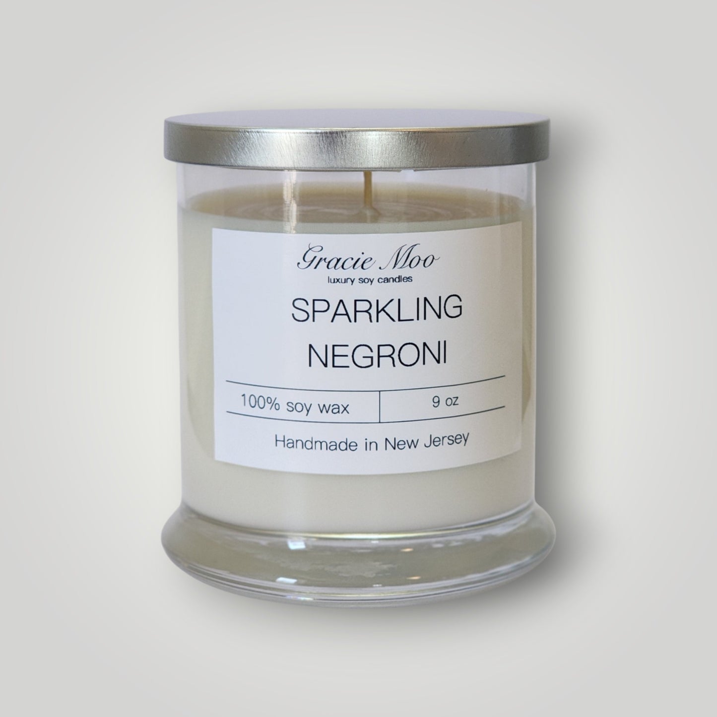 Sparkling Negroni scented candle by Gracie Moo Candles with a stylish glass jar and elegant label design.